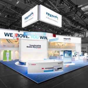 Gesamtansicht des Bosch Rexroth Messestands auf der bauma in München mit abgehängten Bannern und Botschaft „We move. You win.“