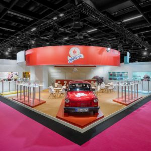 Außenansicht des Halloren Messestands auf der ISM in Köln mit rotem Trabant und Produktpräsentation